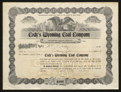 Certificate with black and yellow ink shows intricate bordering, lettering, a seal, signatures, and vignettes of an eagle, train, and coal mine