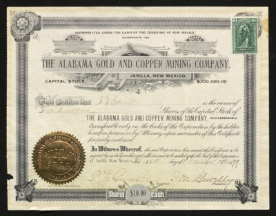 Certificate with blue and black ink shows intricate borders, lettering, signatures, a company seal, an IRS stamp, and a plant and ribbon vignette
