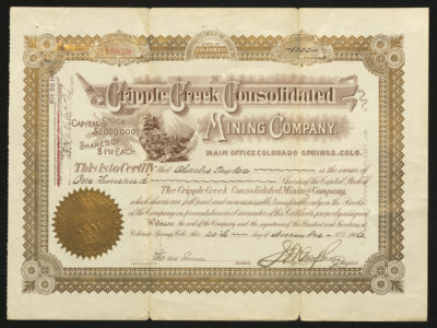 Certificate with brown and gold ink shows intricate bordering, lettering, a company seal, signatures, and a vignette of a mountain scene