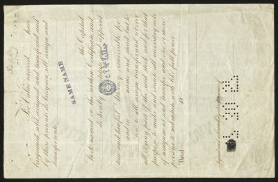 Backside shows legal language, a punched-out date, and a signature